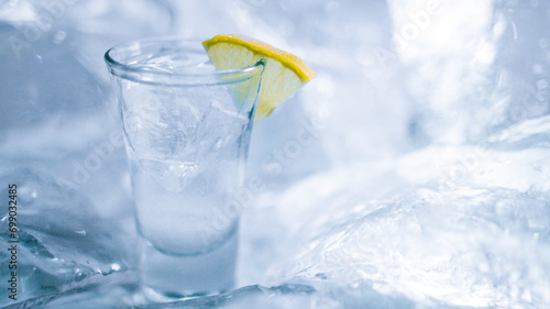 A glass of vodka with ice and lemon