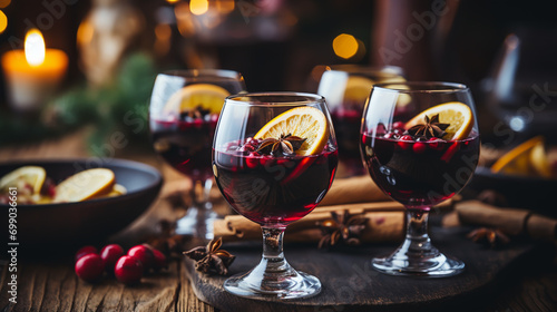 Christmas mulled red wine with spices and fruits on a wooden rustic table. Traditional hot drink at Christmas time photo