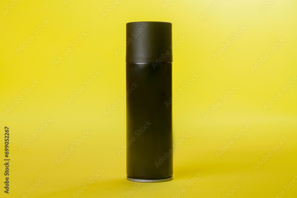 Black spray can isolated on yellow background. Mockup. Can concept. Beauty product concept. Space for text. Mockup. Black spray can isolated on yellow background. Mockup. Can concept. Beauty product concept. Space for text. Mockup.