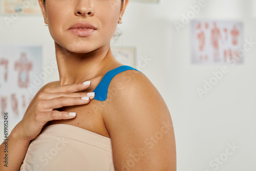 cropped view of attractive young woman with kinesiological tapes on her body during appointment photo