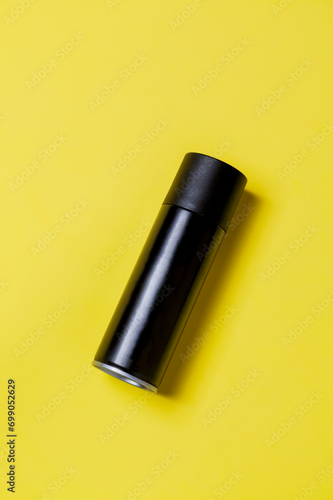 Black spray can isolated on yellow background. Mockup. Can concept. Beauty product concept. Space for text. Mockup. Black spray can isolated on yellow background. Mockup. Can concept. Beauty product concept. Space for text. Mockup.