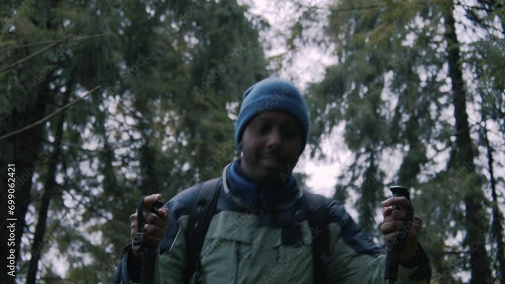 African American hiking guide stops to wait group of tourists and talks with them. Diverse hikers walk with backpacks and trekking poles in forest. Outdoor enthusiasts during expedition. Slow motion. African American hiking guide stops to wait group of tourists and talks with them. Diverse hikers walk with backpacks and trekking poles in forest. Outdoor enthusiasts during expedition. Slow motion.