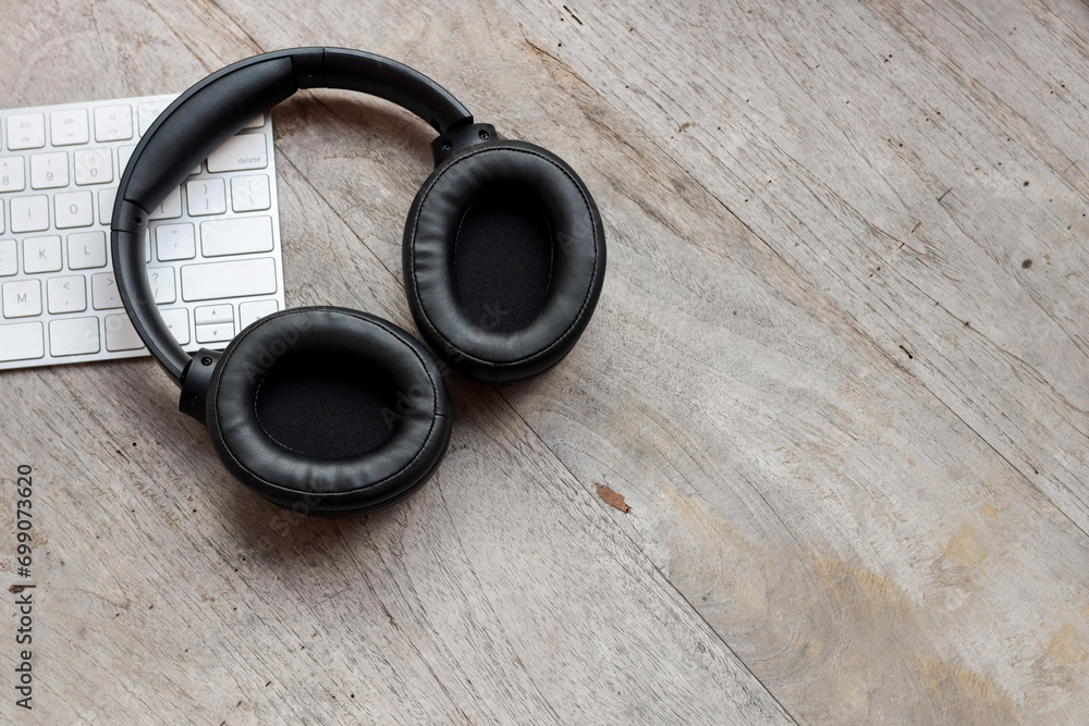 Black headphones on the computer keyboard. Copy space for text, message, etc. Leisure and business concept. Black headphones on the computer keyboard. Copy space for text, message, etc. Leisure and business concept.