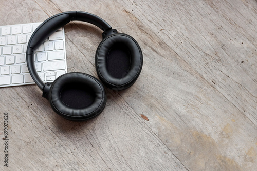 Black headphones on the computer keyboard. Copy space for text, message, etc. Leisure and business concept.