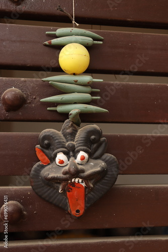 An Indian Black evil eye nazar battu mask with nimbu mirchi or lemon and chilly sign attached by string on iron gate photo