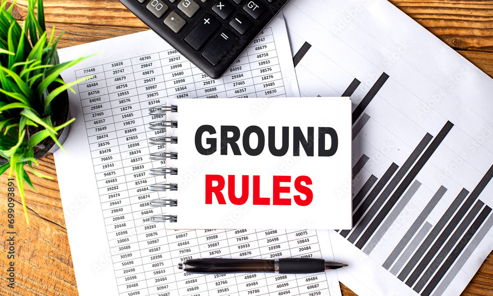 GROUND RULES text on a notebook with chart and calculator StockFoto