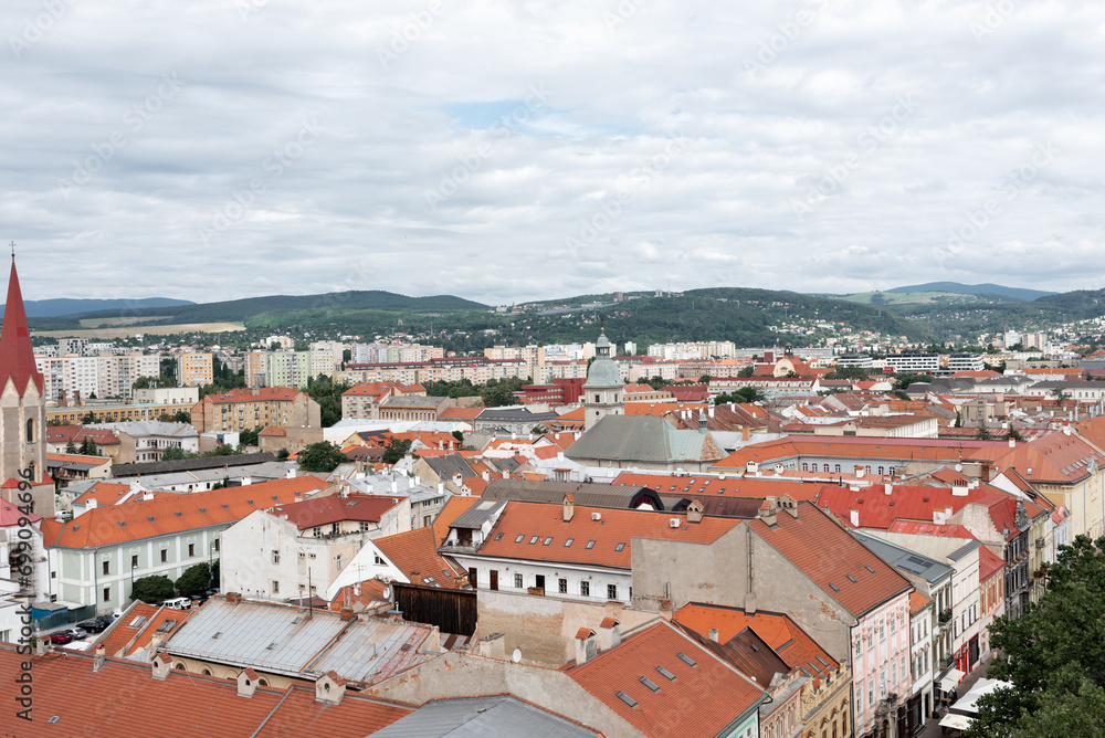 Old historical center of Košice, Slovakia. European city landscape with authentic buildings with red roofs, cloudy sky and mountains on horizon, aerial view