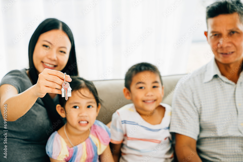 A joyful family poses with mother holding keys to their new house. Reflecting happiness togetherness and the anticipation of new beginnings in their home sweet home. New house A joyful family poses with mother holding keys to their new house. Reflecting happiness togetherness and the anticipation of new beginnings in their home sweet home. New house