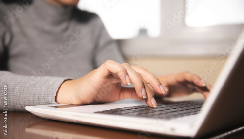 Business woman hands typing on laptop computer keyboard © ARAMYAN