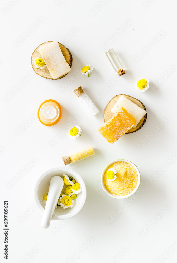 White and yellow chamomile flowers with herbal cosmetic beauty products