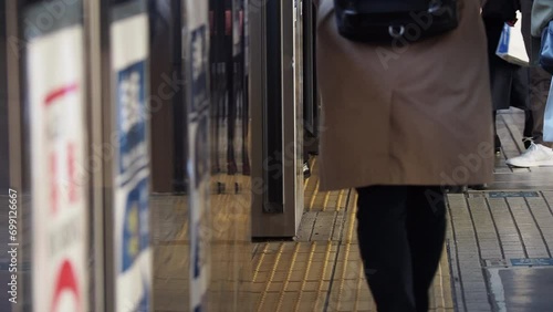 駅のホームで新幹線を乗車する乗客の姿 photo