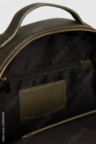 Open women's green Leather Bag inside with pockets and several compartments, interior departments. Open backpack Handbag isolated on White Background. Close up. Banner, advertisment