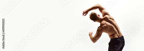 Shirtless young man with relief, strong, healthy, muscular back standing shirtless in pants isolated on white studio background. Concept of beauty, body care, sport. Banner. Empty space to insert text