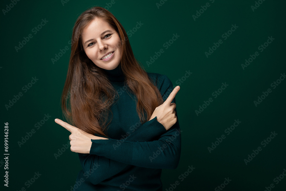 Young pretty woman with long brown hair waving her arms on a green background with copy space Young pretty woman with long brown hair waving her arms on a green background with copy space