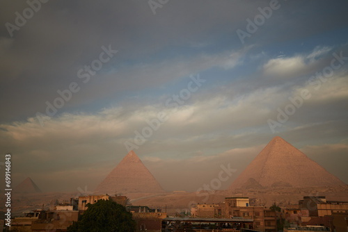 Panoramic view of Giza Pyramids at Sunrise with pastel - coloured sky