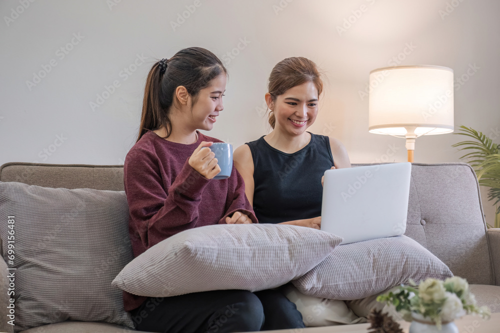Two women communicate with friends and classmates via video link using laptop and smartphone in living room. Friends, friendship, time together. Two women communicate with friends and classmates via video link using laptop and smartphone in living room. Friends, friendship, time together.