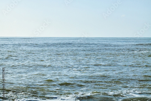 Blue ocean scene with horizon with bright sky. Calm seascape.