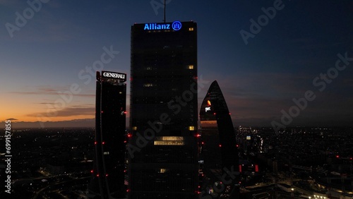 ITALY, MILAN 12-27-2023 night drone aerial view of (The Straight One), Generali (The Twisted One), PwC The Curved On) in CityLife district  shopping area new skyline skyscrapers - Milan by night  photo