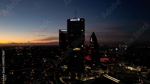 ITALY, MILAN 12-27-2023 night drone aerial view of (The Straight One), Generali (The Twisted One), PwC The Curved On) in CityLife district  shopping area new skyline skyscrapers - Milan by night  photo