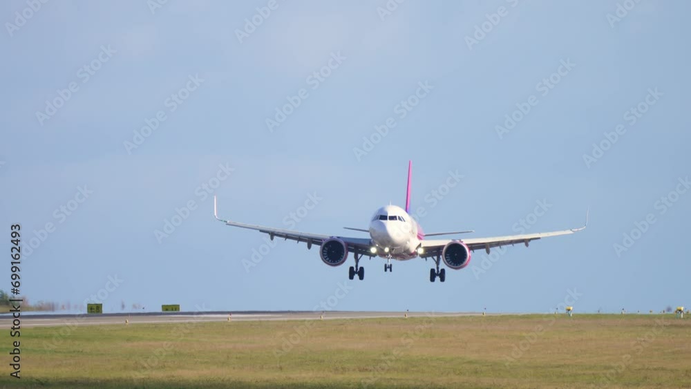 Slow motion shot landing jet liner. Passenger plane fly down and touch ground. Airplane approaching before landing at airport. Chassis touching down runway. Front view from of runway Slow motion shot landing jet liner. Passenger plane fly down and touch ground. Airplane approaching before landing at airport. Chassis touching down runway. Front view from of runway