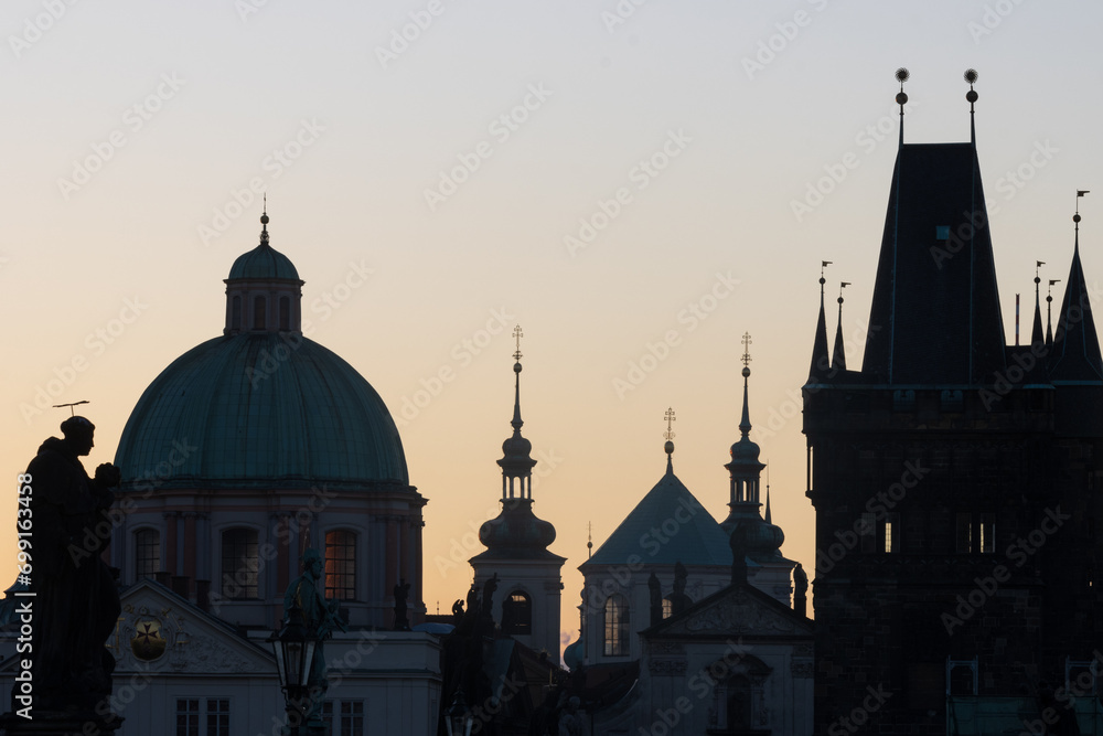Silhouette of Prague's towers at dawn.