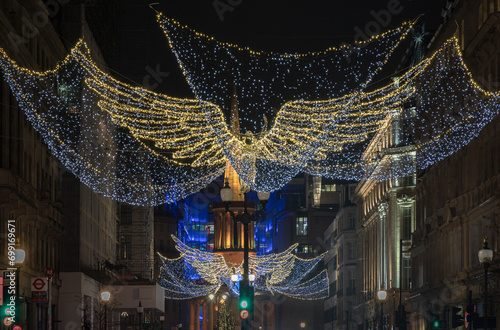 Flying angel Christmas decoration led lights display. View of the traditional Christmas decoration lights hanging above Regent Street during dusk, The Spirit of Christmas, Light Festival in London.