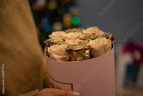 Bouquet of Pink and gold roses in a pink gift box. Floral romantic composition with jewelry for engagement present for bride.Wedding