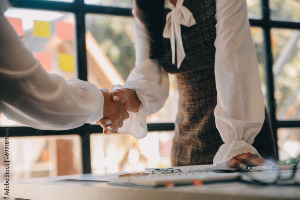 Obraz premium Meeting and greeting concept, Two confident Business handshake and business people after discussing good deal of Trading contract and new projects for both companies, success, partnership, co worker.