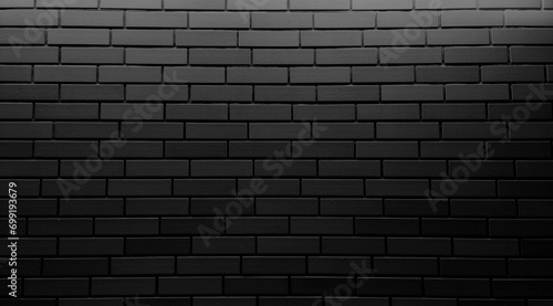 dark black modern brick tile wall use as background with blank space for design. black ceramic tile with light from above use as background. modern ceramic tiles to decorate building facade.