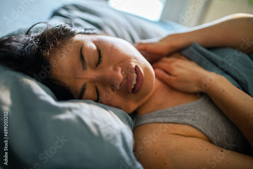 Distressed Woman Experiencing Neck Pain in Bed photo