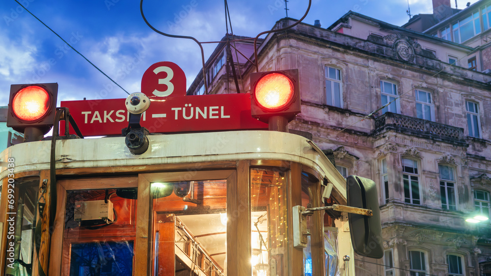 Historical  Red Tram at night with orange vehicle lights in Taksim, Istiklal avenue Istanbul, Turkey 