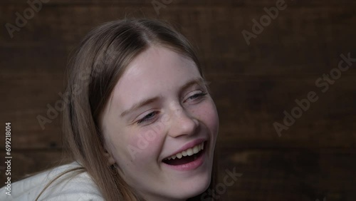 Close-up portrait of sleepy beautiful young girl yawning on wooden background. Expressions concept