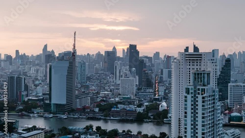 Sunrise over crowded office building with Chao Phraya river in business district at Bangkok, Thailand photo