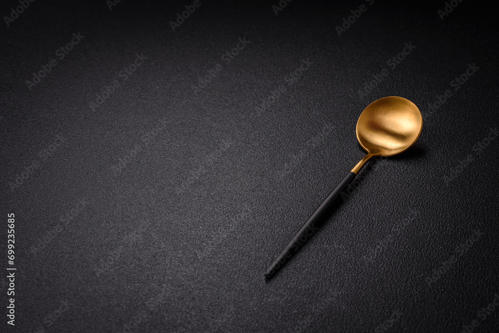 Empty metal spoon on dark textured concrete background Empty metal spoon on dark textured concrete background