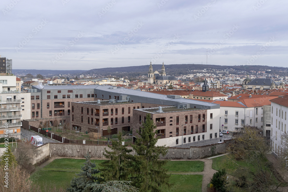 Nancy, France - December 27th 2023 : View of Nancy from building, with garden and modern real estate building, the Nancy Cathedral and wooded hill in the background.
