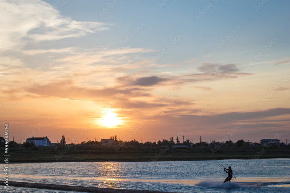 Sportsman kitesurfing during sunset