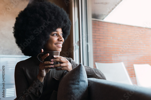 Cheerful black woman with cup of coffee photo