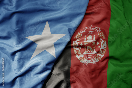 big waving national colorful flag of afghanistan and national flag of somalia .