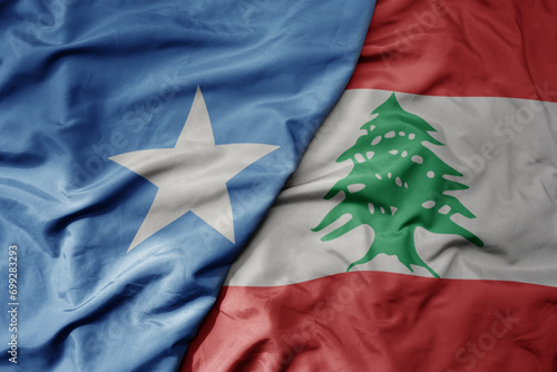 big waving national colorful flag of lebanon and national flag of somalia . photo