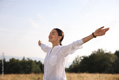 Feeling freedom. Happy woman with wide open arms outdoors
