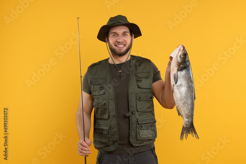 Fisherman with rod and catch on yellow background