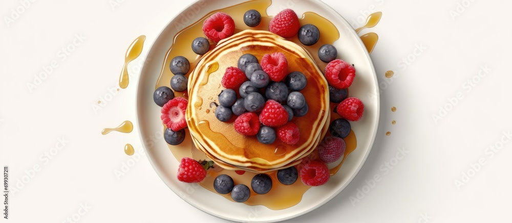 Delicious Pancakes with Berries and Maple Syrup on the table