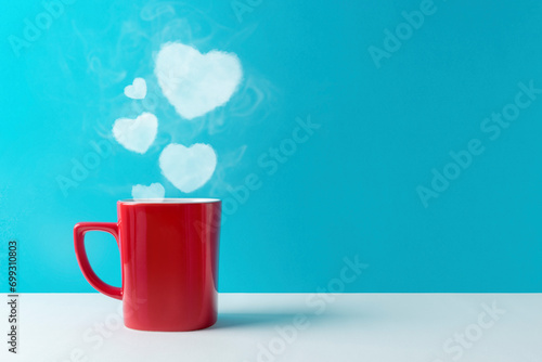 Heart silhouette made of steaming coffee or hot drink on blue ba