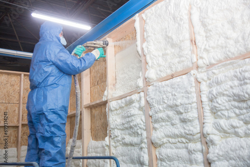 Insulation of walls with foam, energy and heat saving of walls, worker treats walls with foam photo