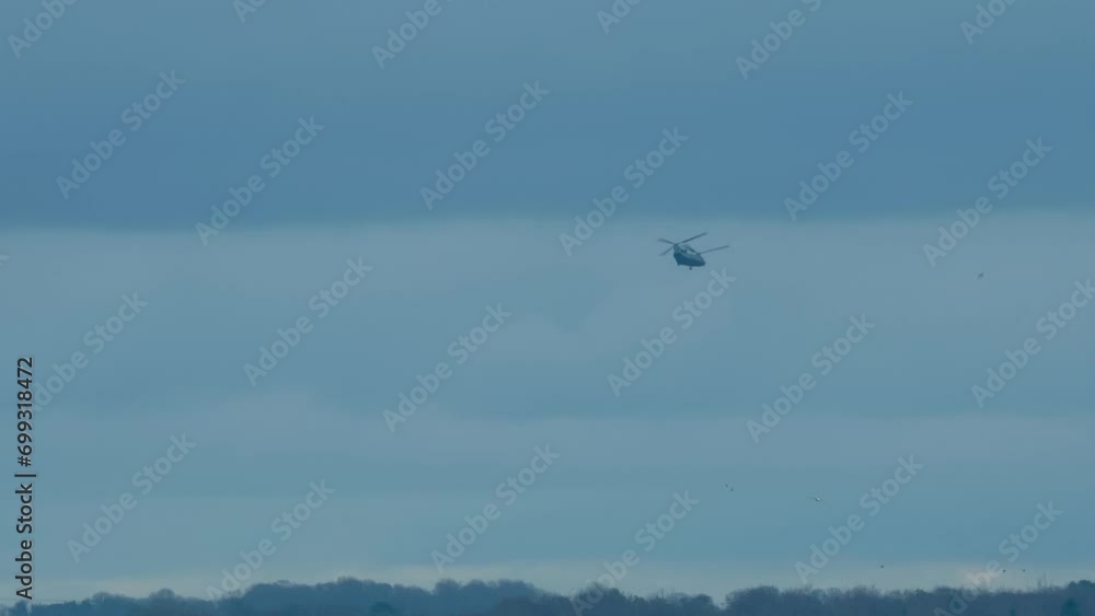 RAF Chinook tandem-rotor helicopter flying fast and low in a cloudy blue grey sky on a military battle exercise, Wilts UK RAF Chinook tandem-rotor helicopter flying fast and low in a cloudy blue grey sky on a military battle exercise, Wilts UK