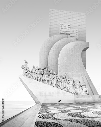 Black and white photograph of a running girl at the seafarers' monument Padrao dos Descobrimentos on the river Tagus in Lisbon, Portugal, Europe photo