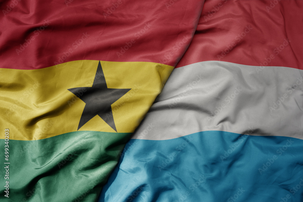 Fototapeta premium big waving national colorful flag of luxembourg and national flag of ghana .