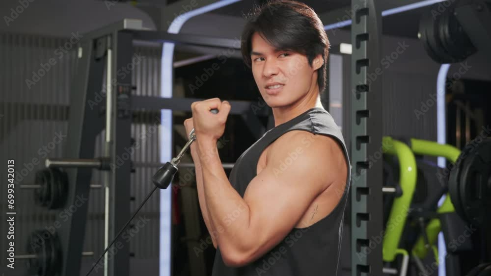 Concept of fitness and exercise - a muscular male athlete pulling a cable tricep rope during a strength training session. lifestyle and people concept Concept of fitness and exercise - a muscular male athlete pulling a cable tricep rope during a strength training session. lifestyle and people concept