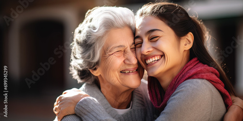 Generational embrace between a joyful elderly woman and young adult, expressing love and family connection photo