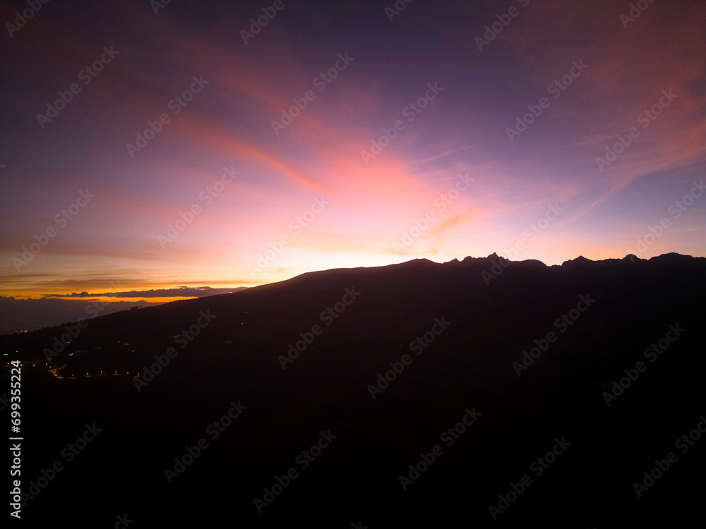 Obraz premium Fondo puesta de sol turquesa rodeado de montañas.